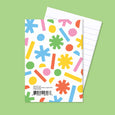 Small pocket notebook with colorful illustrations of shapes on the cover and lined paper inside.