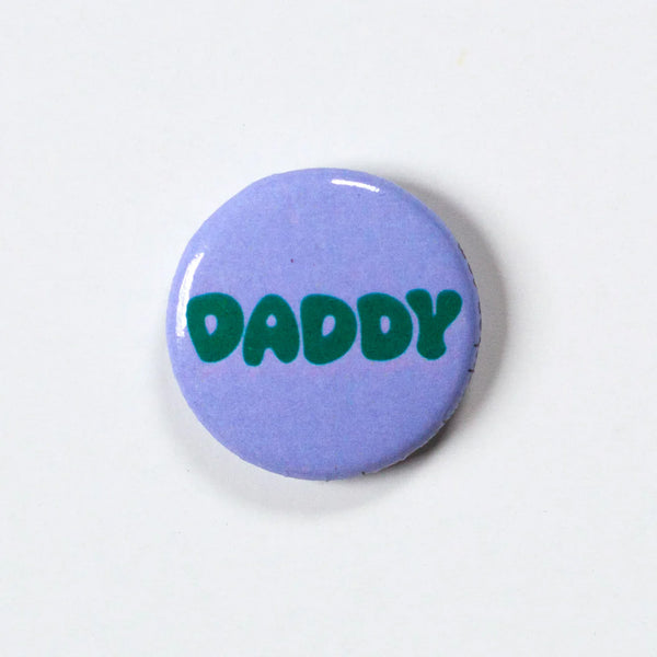 Lavender 1 inch button with the words DADDY in emerald green round letters