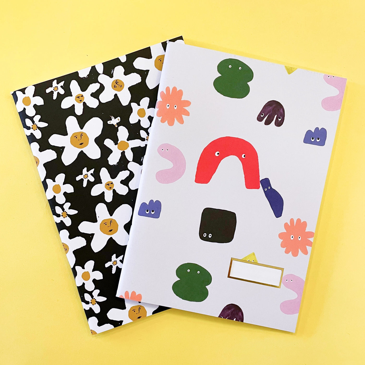 Set of two notebooks with funny face illustrations on the cover by Atelier Mave