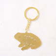 Back of a gold toad keychain with the imprint lorien stern on it
