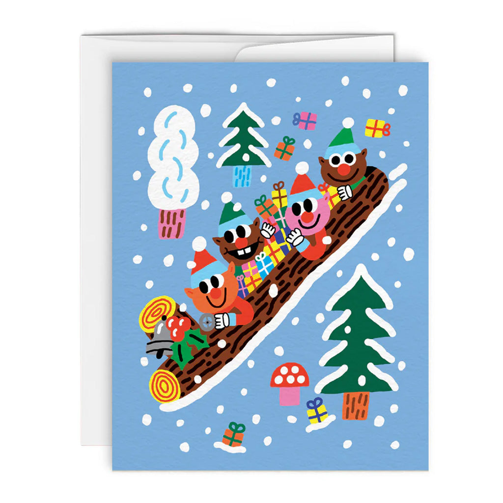 Greeting card with illustrations of elves holding presents riding a log sleigh with pine trees around them, on a bright blue background.