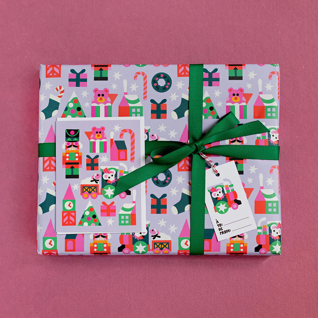 Small train gift wrap with holiday trees, presents and a small train illustration showing a mouse driving a tiny train.