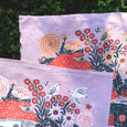 Close up detail of tea towel with drawings by Phoebe wahl of mushroom houses and flowers