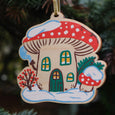 Wooden Winter Mushroom House Ornament with a red cap mushroom and snow on the ground