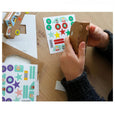 Paper car craft kit for kids being assembled with cardboard cars and stickers