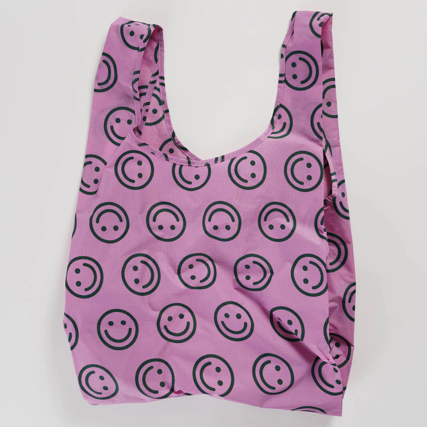 Baggu reusable tote bag in standard size with a happy face pattern in raspberry color