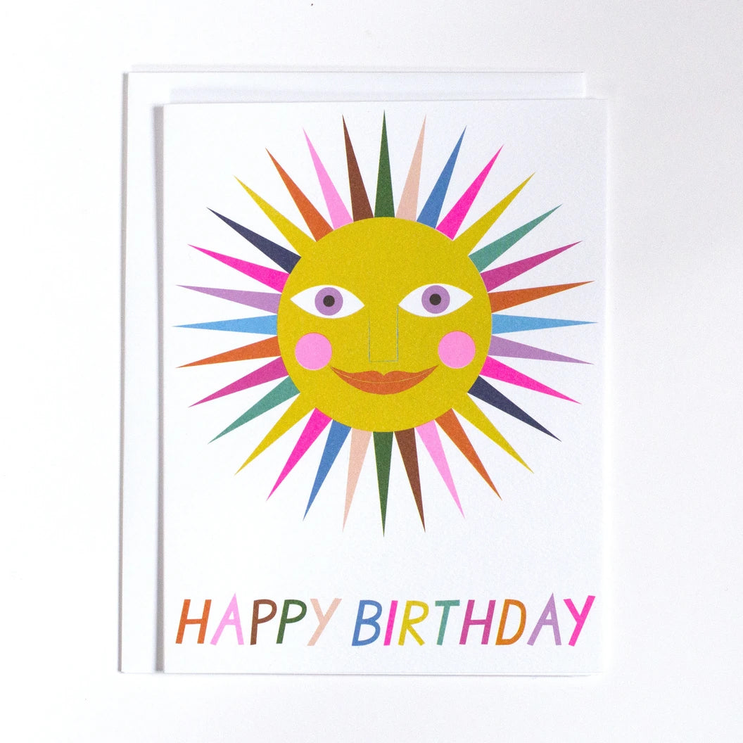 Banquet Greeting Card with a Sunshine that has rainbow rays and "happy birthday" written in rainbow letters along the bottom on a white background