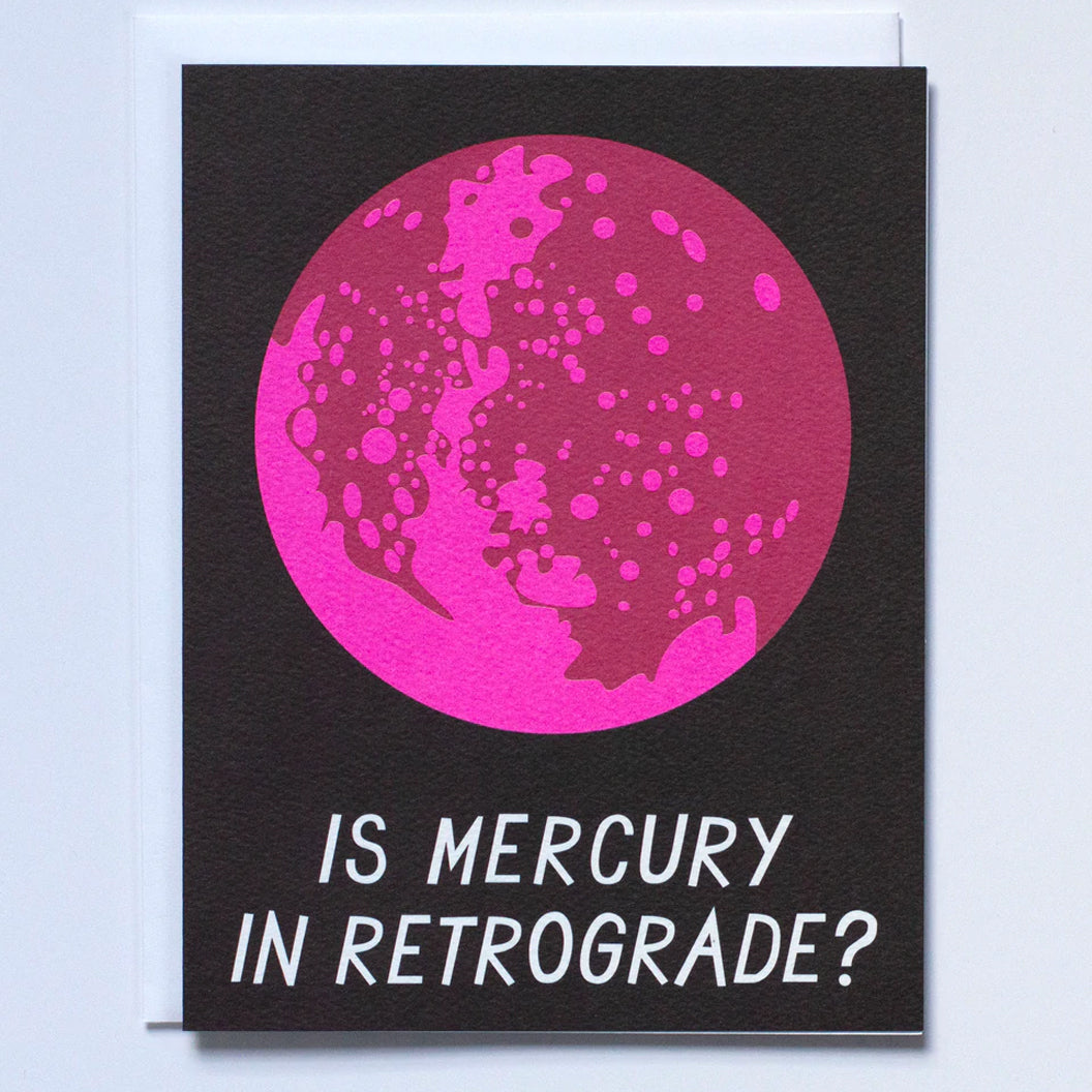 Blank Greeting card on black paper with the text "Is Mercury in Retrograde?" and a big pink Mercury illustration above