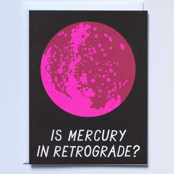 Blank Greeting card on black paper with the text "Is Mercury in Retrograde?" and a big pink Mercury illustration above