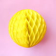 Paper honeycomb ball decoration in yellow and 8 inches across