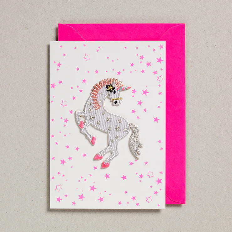 Iron on Patch Greeting Card with a unicorn iron on patch in white and pink and pink stars surrounding it on the greeting card