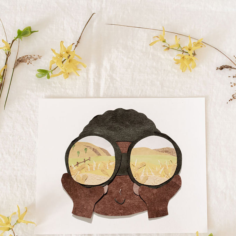 Neets Anita Cheung paper cut art print with a child looking though binoculars at an open hilly landscape