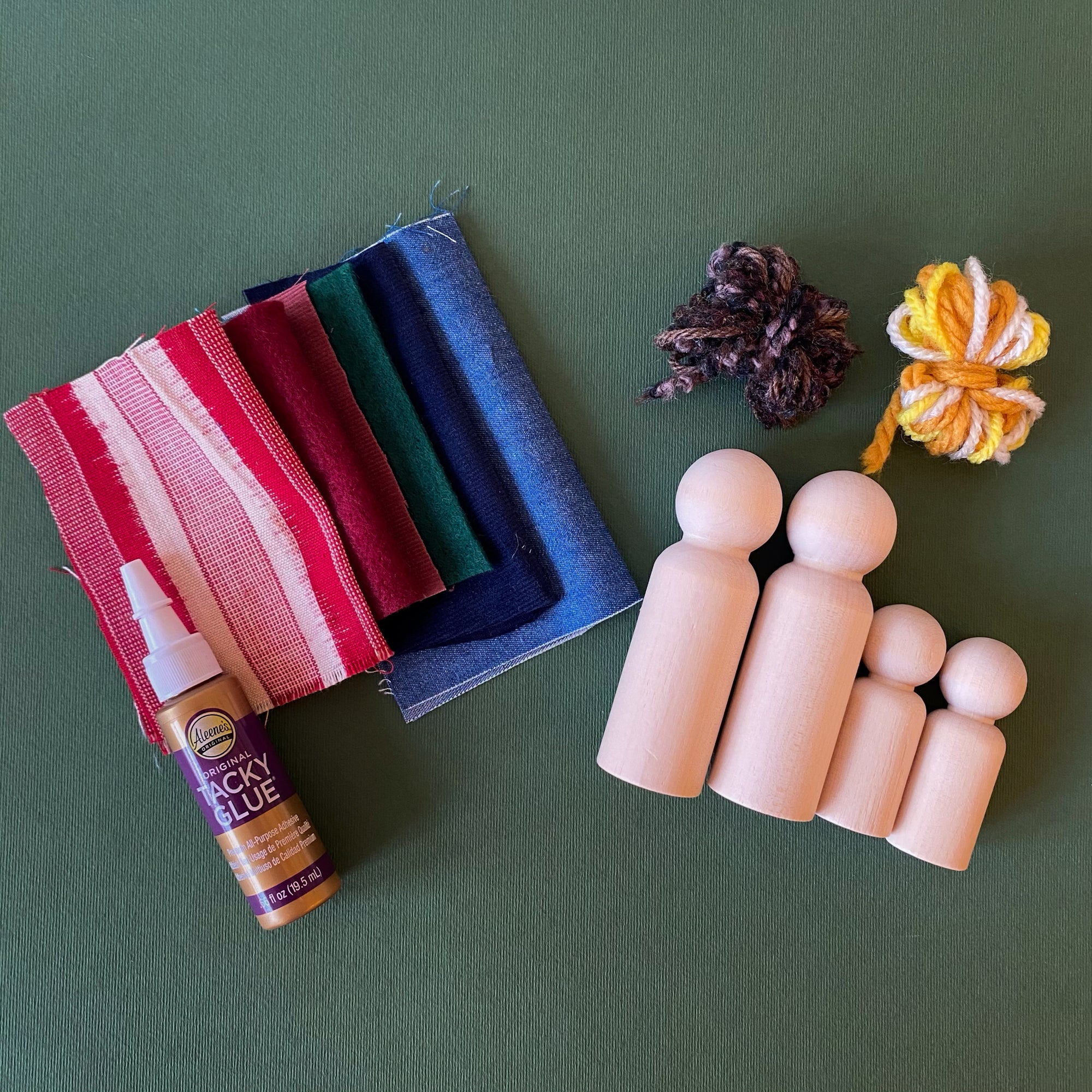 Peg Doll craft kit in a winter theme with fabric in blues, reds and green, along with glue and string