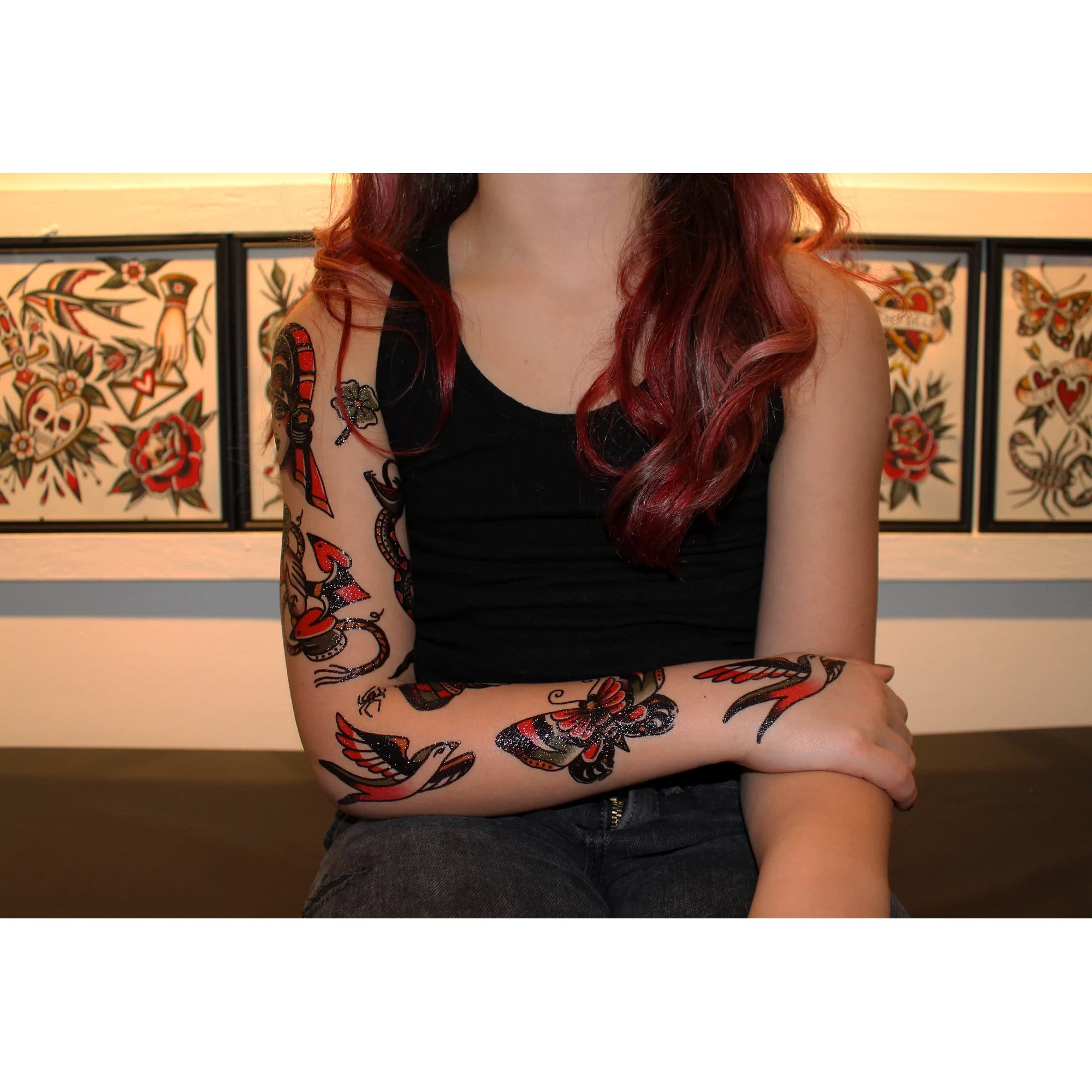 Arms showing temporary tattoos of a butterfly, birds and more