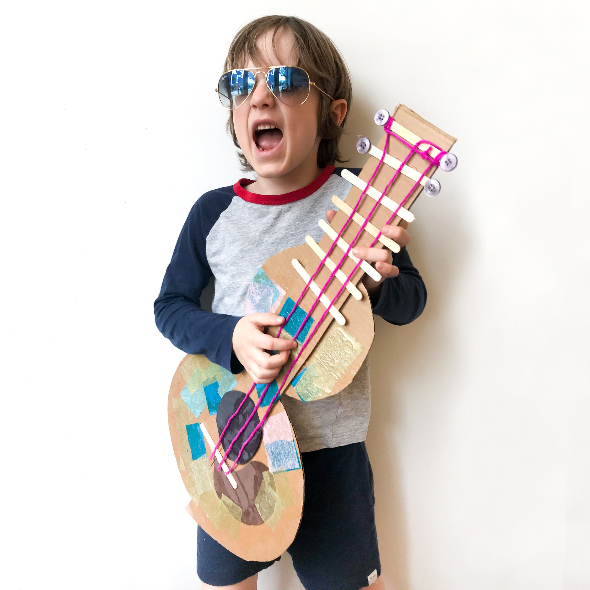 Boy with handmade guitar from virtual Art class inspired by Joni Mitchell